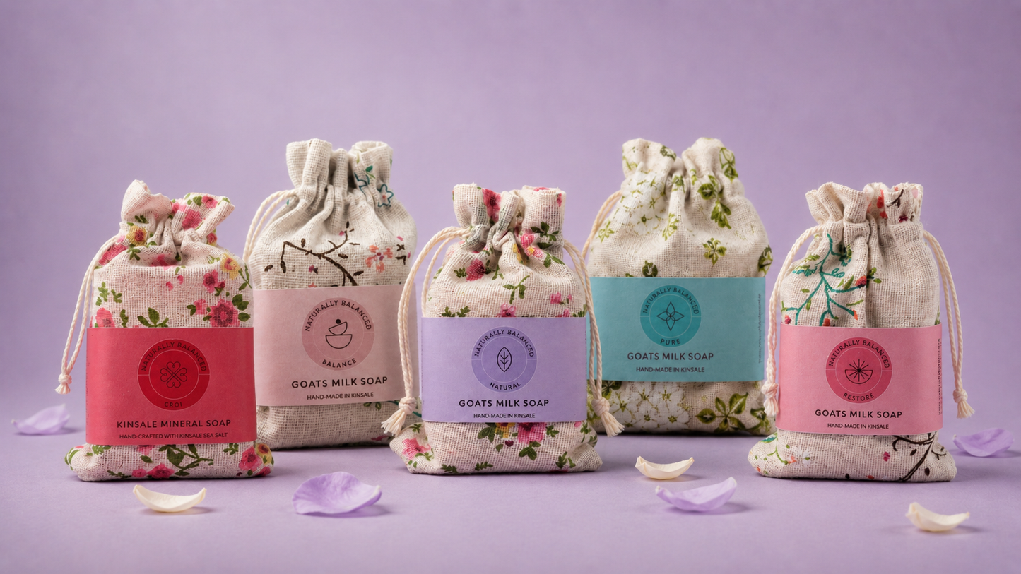 Set of goat's milk soaps in decorative bags on a purple background