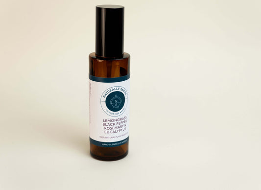 Bottle of lemongrass, black pepper, rosemary, and eucalyptus essential oil on a beige background