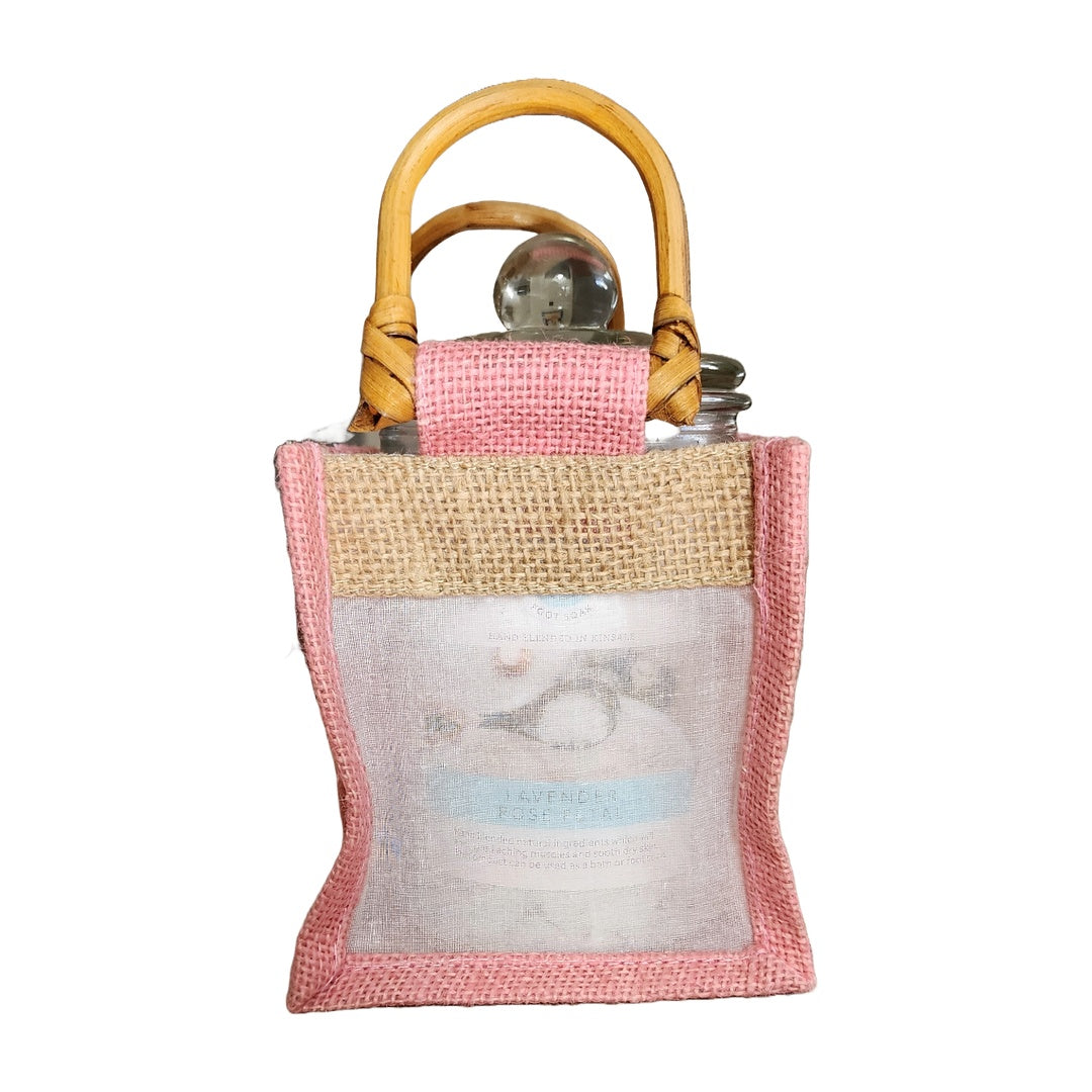 Small pink and beige bag with a bamboo handle on a white background