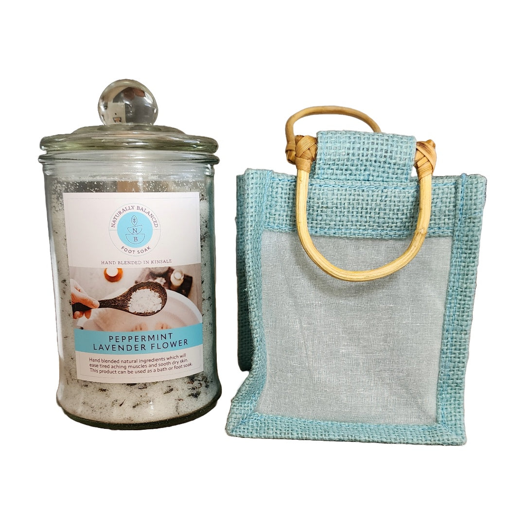 Jar of bath salts with a label and a textured bag with wooden handles on a white background