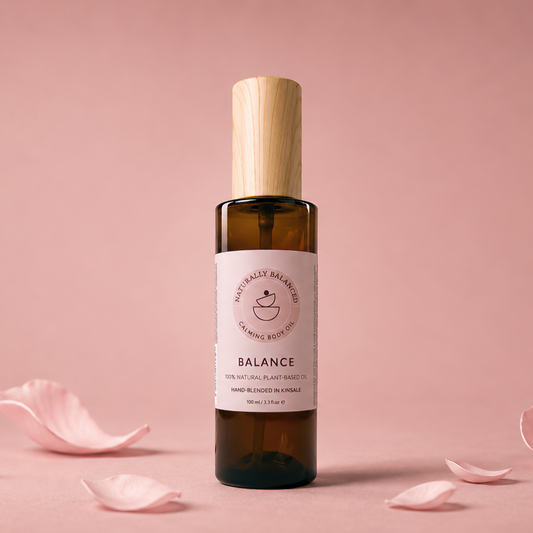 Bottle of 'Balance' with rose petals on a pink background