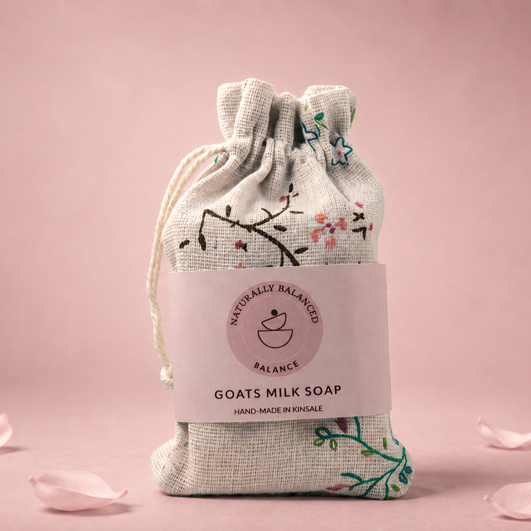 Goats milk soap in a drawstring bag with floral design on a pink background