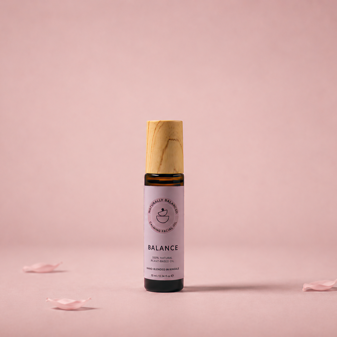 Vial labeled 'Balance' on a pink background with scattered petals