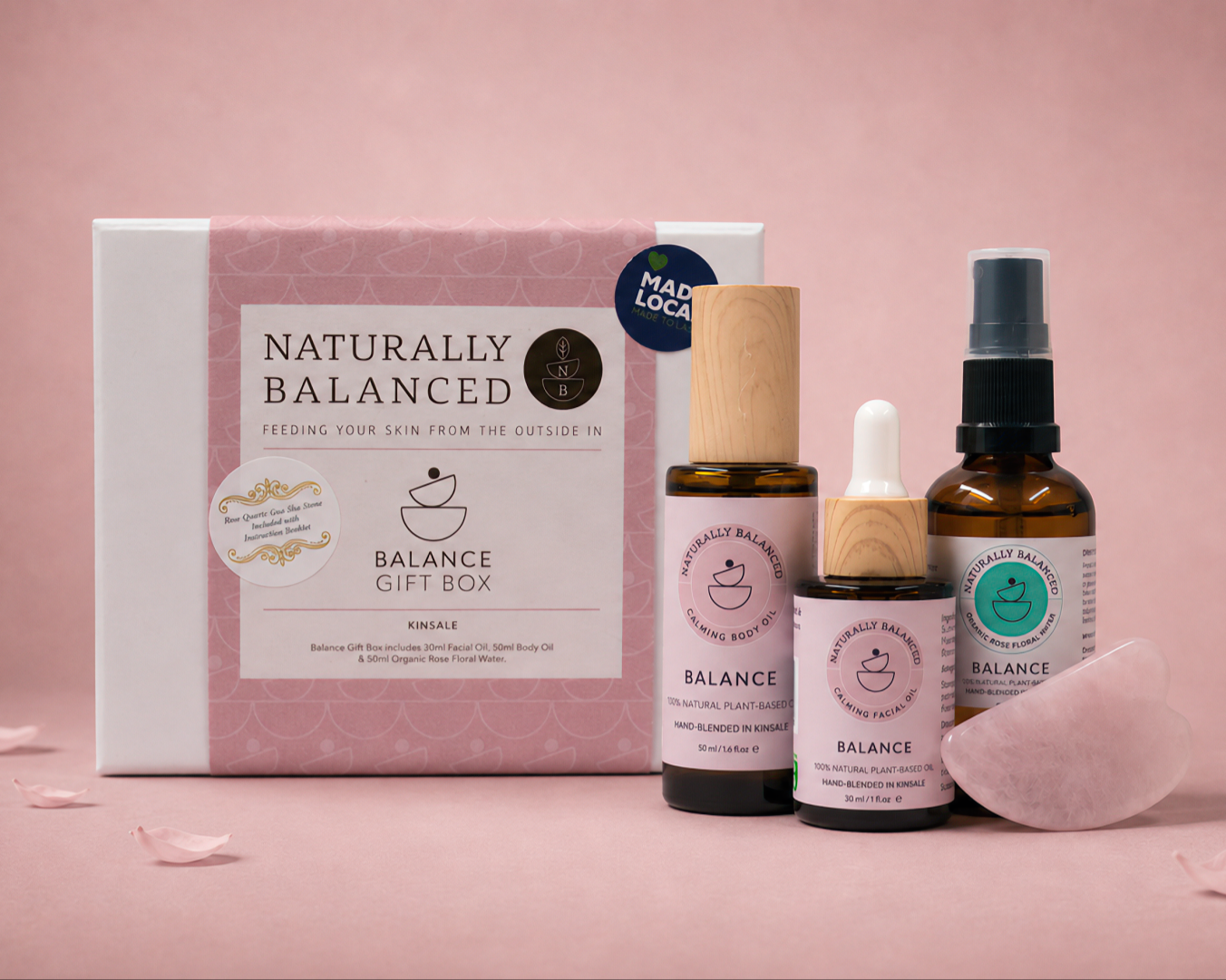 Naturally Balanced skincare products on a pink background with rose petals.