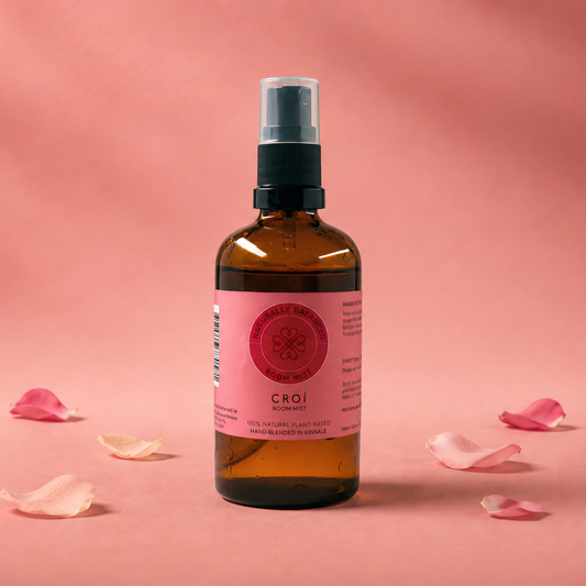 Bottle of CAOI product with pink label on a pink background with scattered rose petals