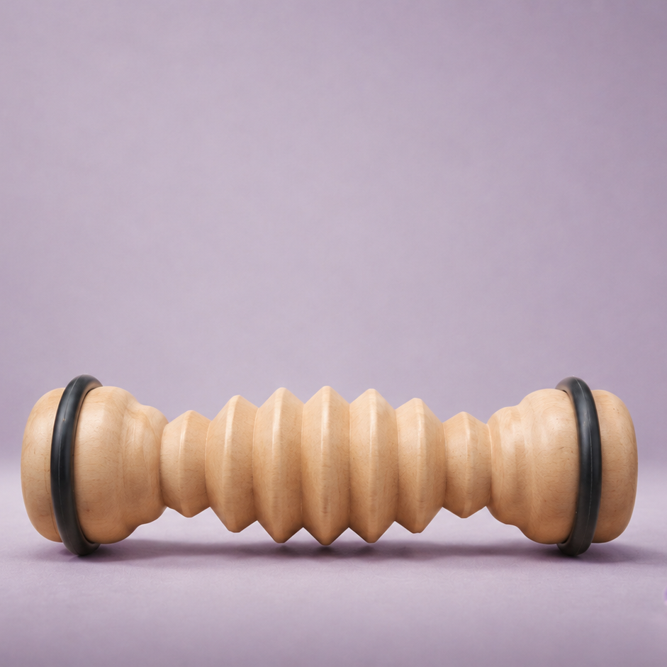 Wooden massage roller with black ends on a purple background