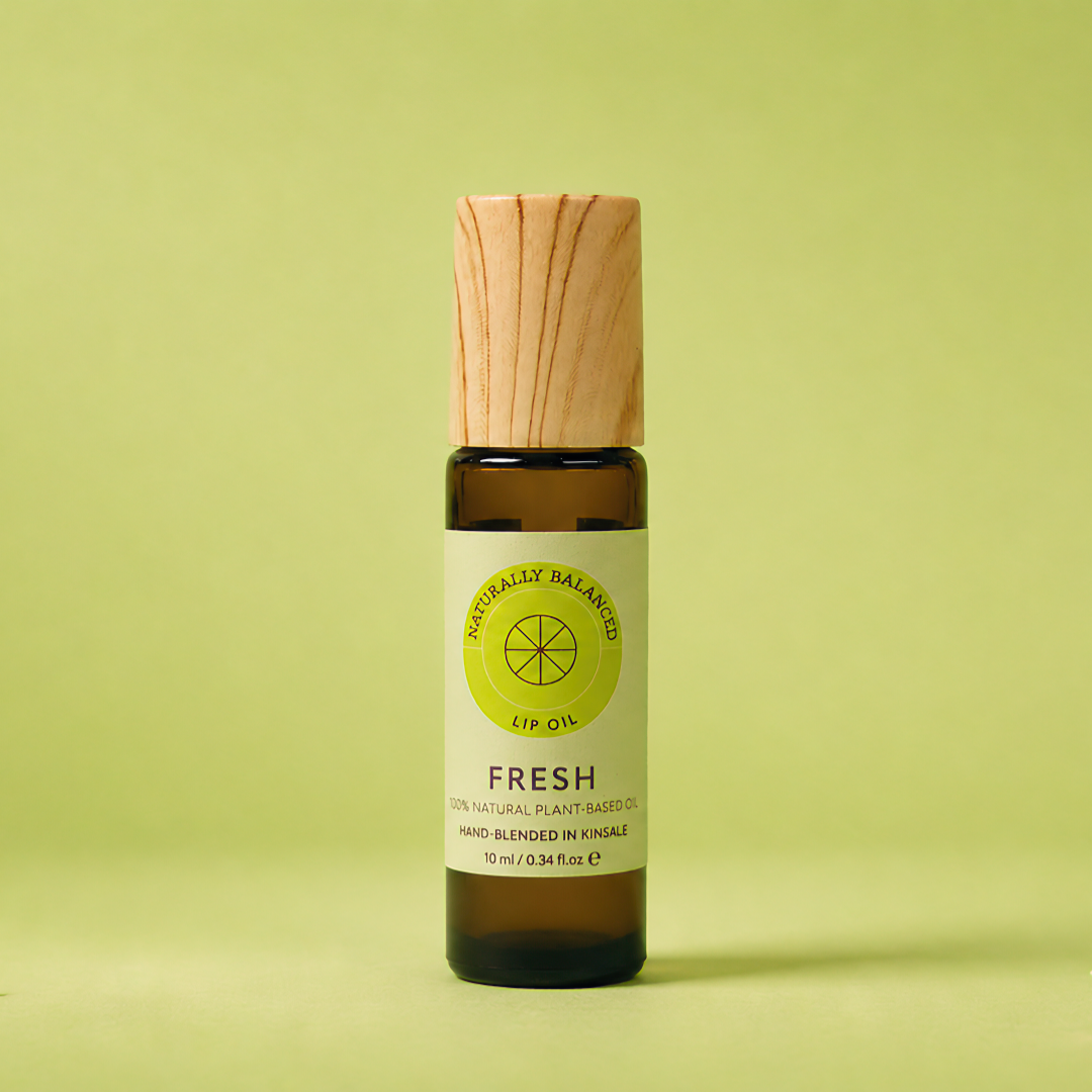 Bottle of fresh-scented product with wooden applicator on a light green background