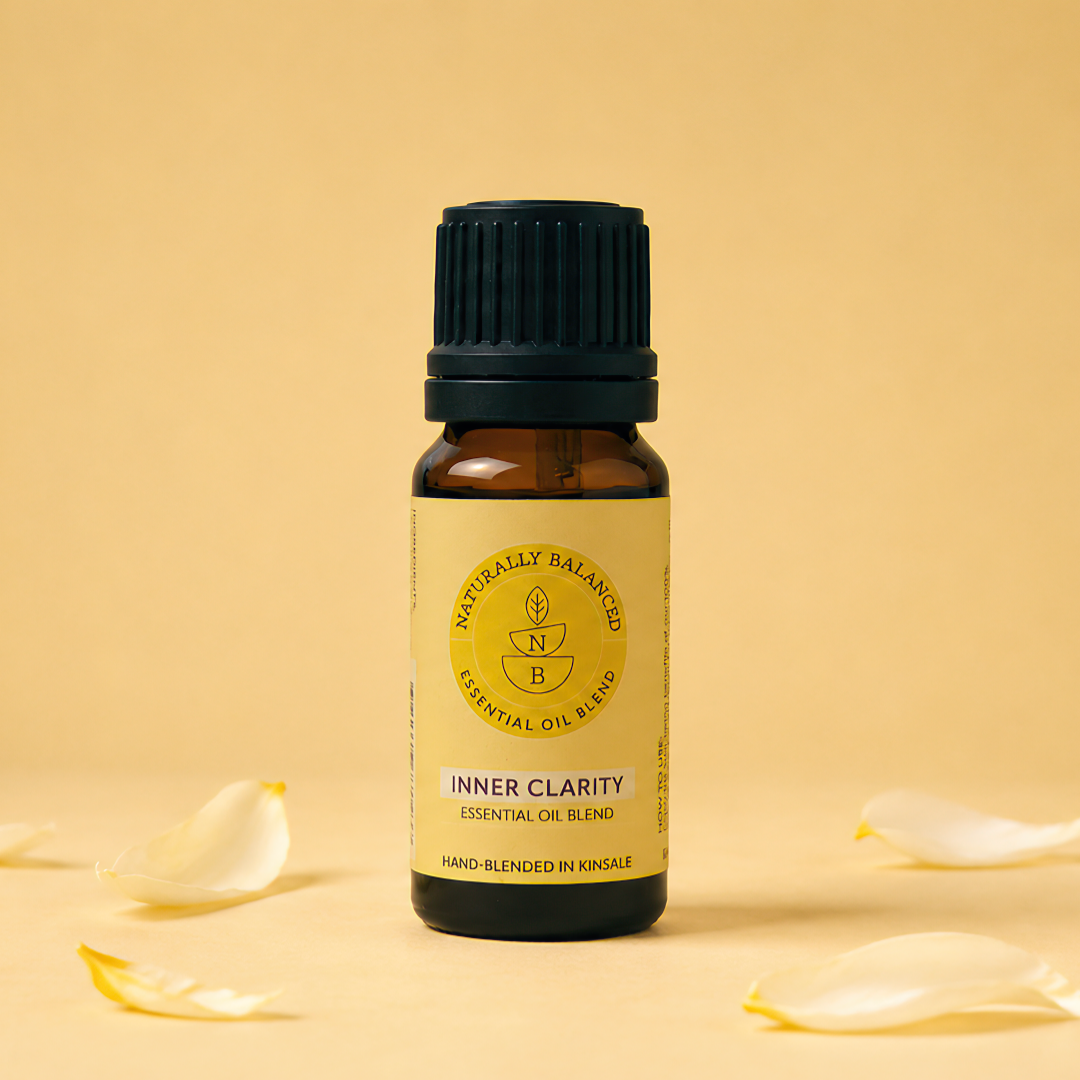 Essential oil bottle labeled 'Inner Clarity' with flower petals on a beige background