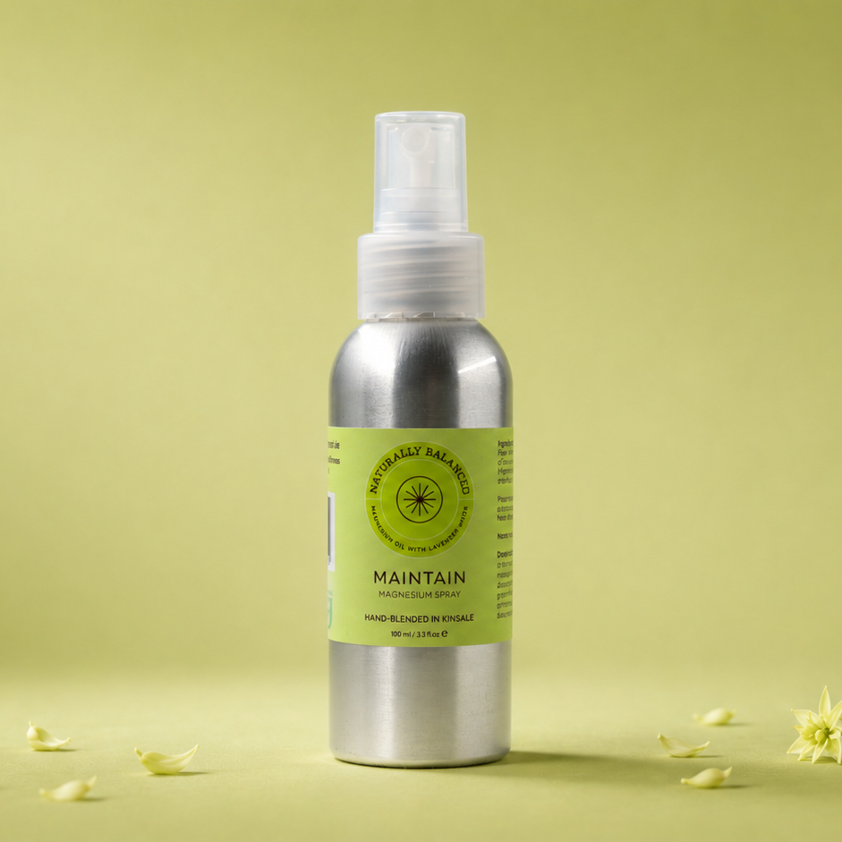 Silver spray bottle with a green label on a light green background