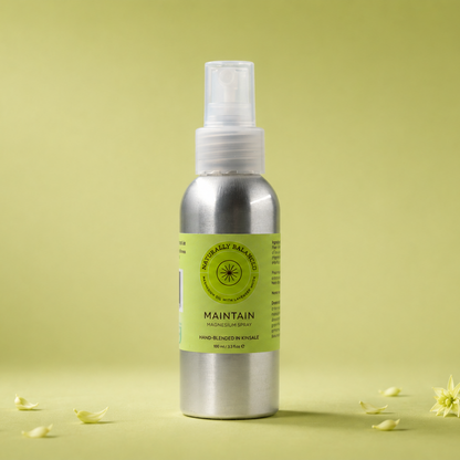 Silver spray bottle with a green label on a light green background