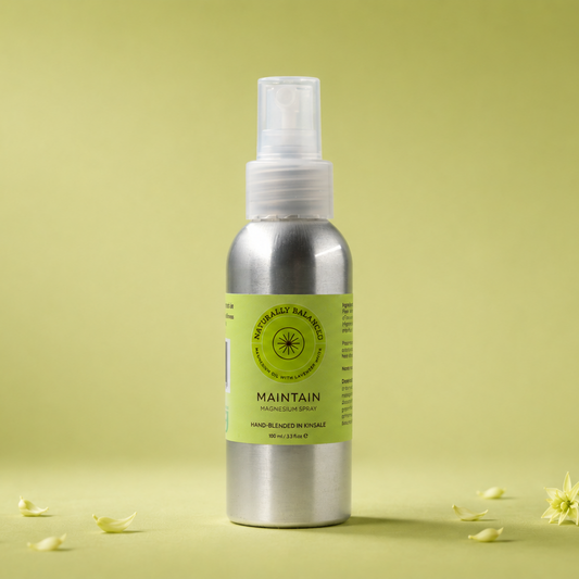 Silver spray bottle with a green label on a light green background