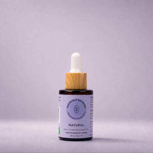 Bottle of natural skincare product with dropper on a light purple background