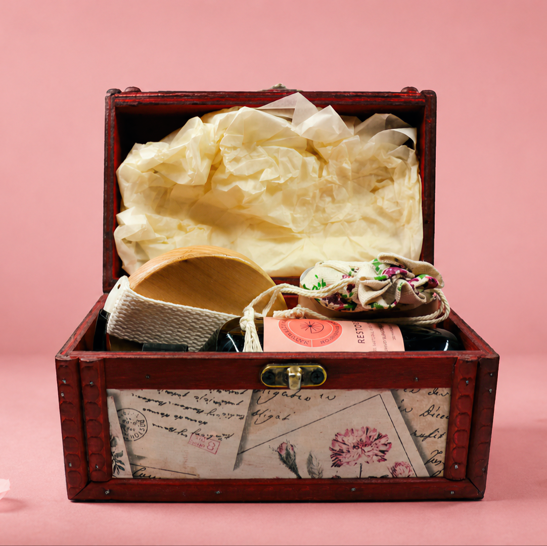 Wooden jewelry box with jewelry on a pink background