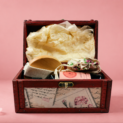 Wooden jewelry box with jewelry on a pink background