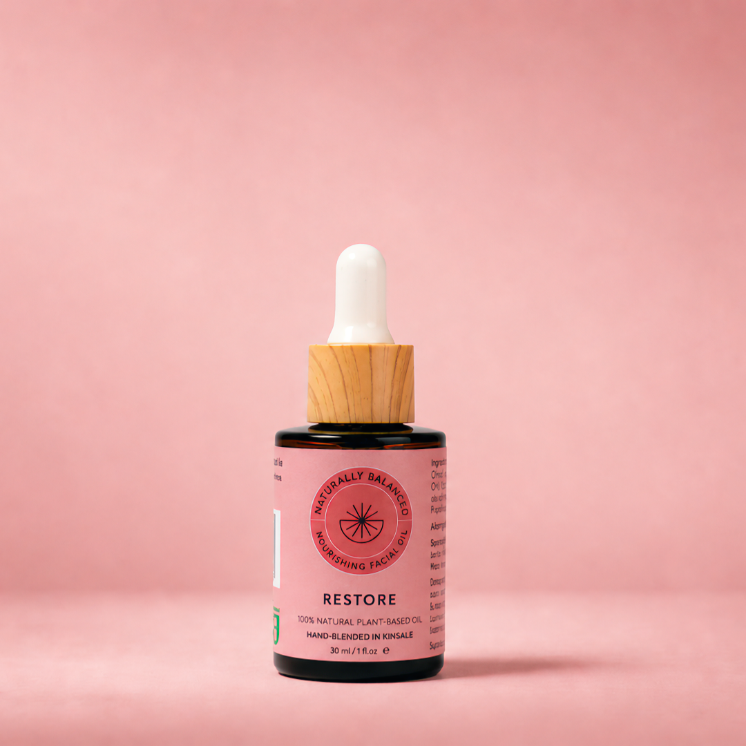 Bottle of 'Restore' serum with dropper on a pink background