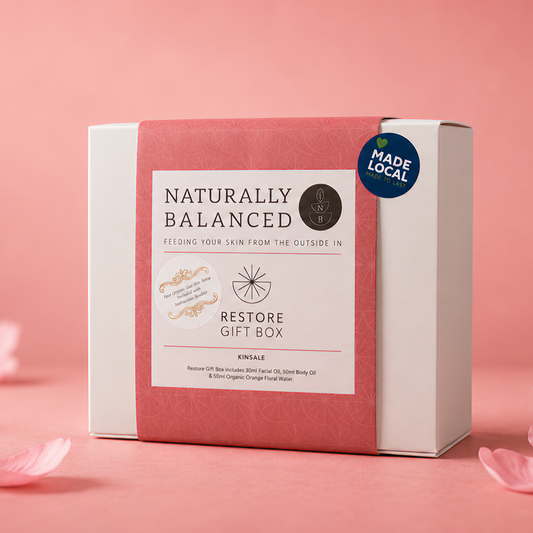 Gift box labeled 'Naturally Balanced' on a pink background with cherry blossoms.
