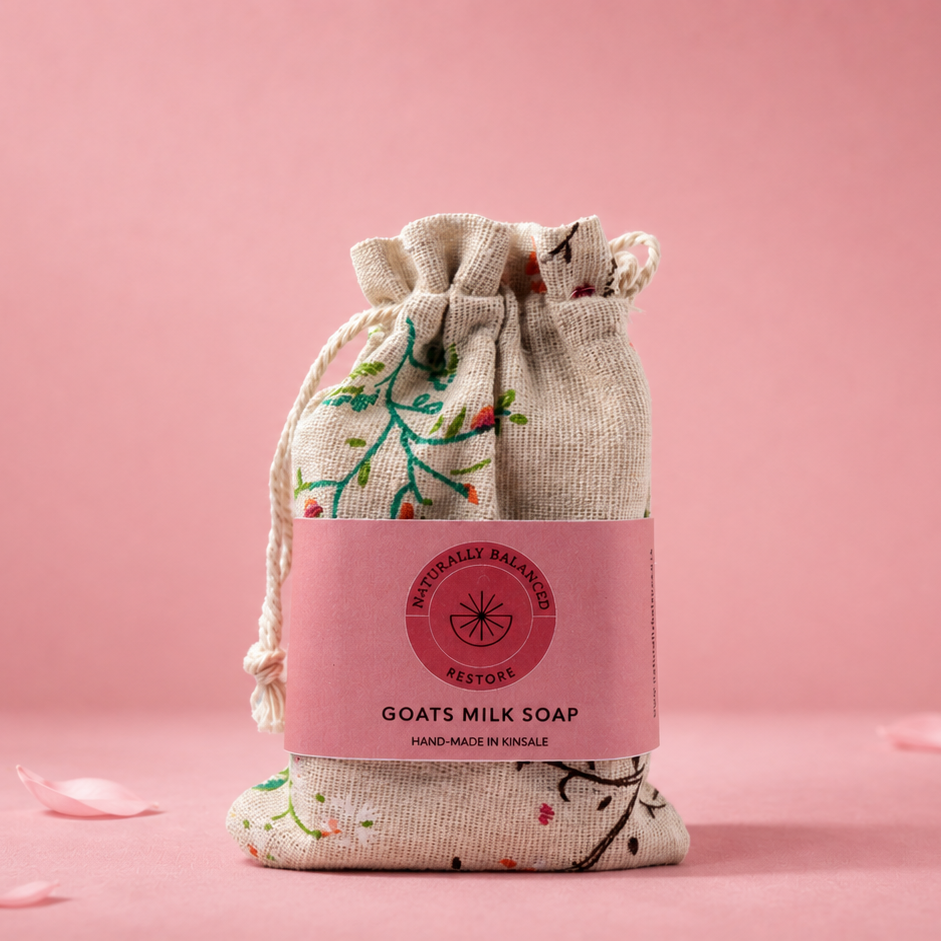Goats milk soap in a drawstring bag on a pink background