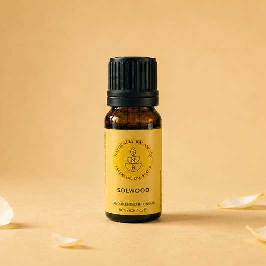 Bottle of Solwood essential oil with flower petals on a beige background