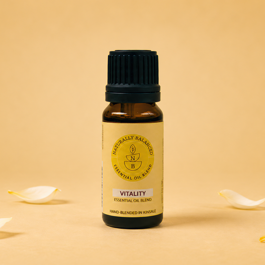 Essential oil bottle labeled 'Vitality' on a beige background with petals.